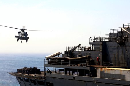 An MH-60S Seahawk helicopter approaches the Military Sealift Command fast combat support ship USNS Bridge (T-AOE 10) during a vertical replenishment with the dock landing ship USS Comstock (LSD 45) in 110517-N-RC734-066