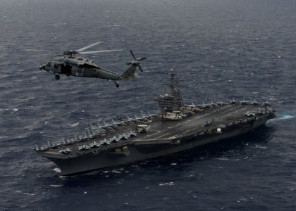 An MH-60S Sea Hawk helicopter hovers above the aircraft carrier USS Nimitz (CVN 68) during a photo exercise with the Indian Navy and Japan Maritime Self-Defense Force during exercise Malabar 2017 photo