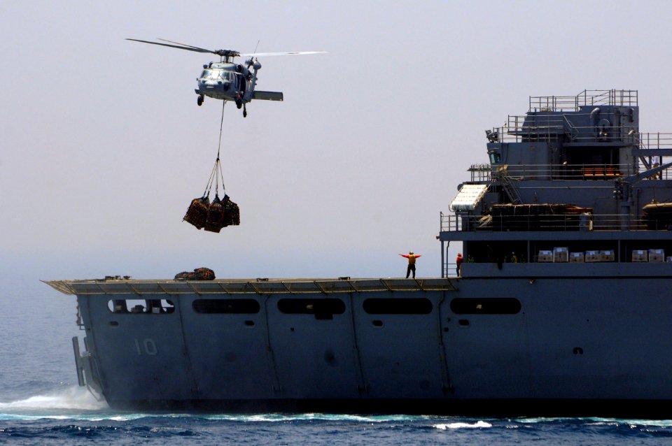 An MH-60S Seahawk helicopter assigned to Helicopter Sea Combat Squadron (HSC) 23 returns pallets to the fast combat support ship USNS Bridge (T-AOE 10) after a vertical replenishment-at-sea with dock landing 110517-N-RC734-290