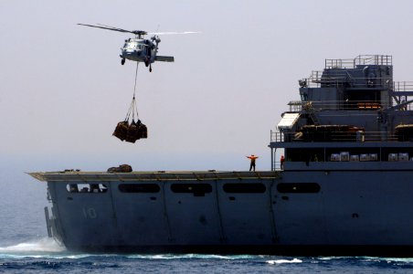 An MH-60S Seahawk helicopter assigned to Helicopter Sea Combat Squadron (HSC) 23 returns pallets to the fast combat support ship USNS Bridge (T-AOE 10) after a vertical replenishment-at-sea with dock landing 110517-N-RC734-290