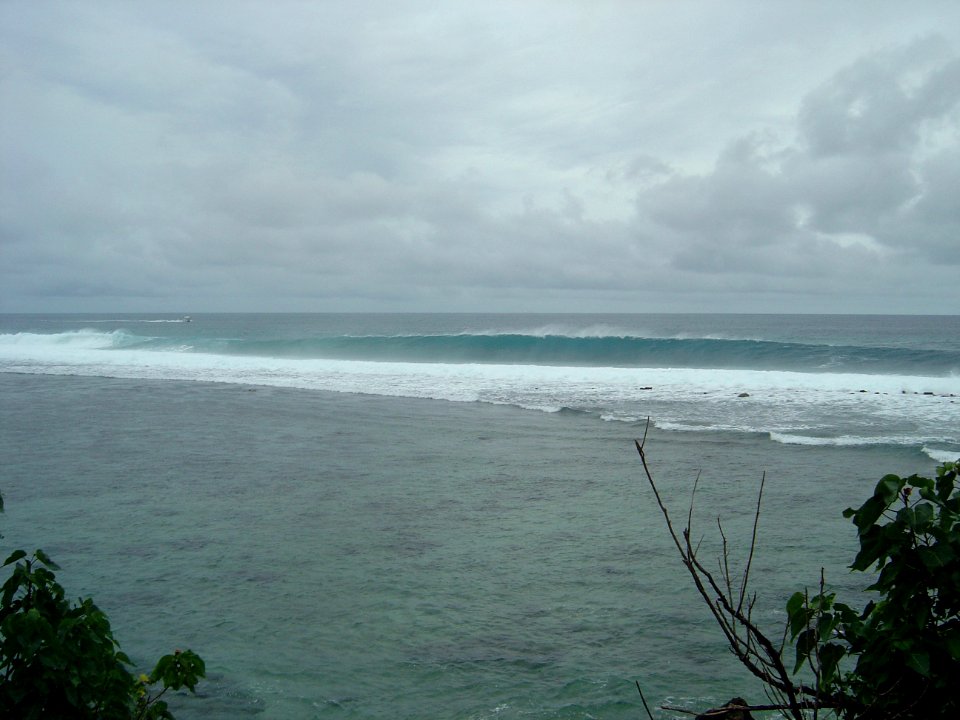 An offshore wind hollows out the long Pacific swell striking the Guam reef (line380641873)