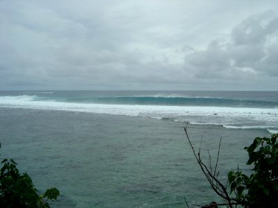 An offshore wind hollows out the long Pacific swell striking the Guam reef (line380641873)