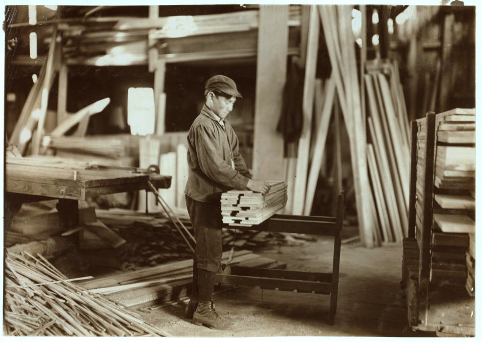 Boy probably about 13 years old, tying strips which he has taken away from the planer. Schultze Waltum Co., Planing Mill. LOC nclc.05372