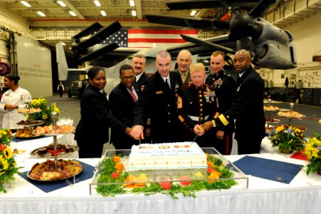 Brian A. Nichols, second from left, the U.S. ambassador to Peru, U.S. Service members and other officials cut a cake during a reception on the amphibious assault ship USS America (LHA 6) in Callao, Peru, Sept 140901-N-LQ799-279