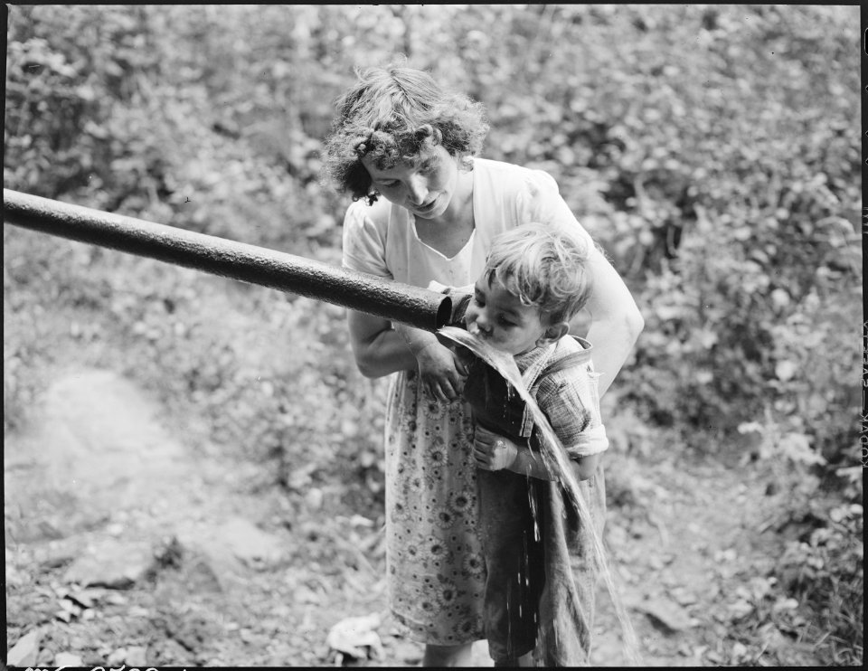 Child of miner drinking from water supply. Dixie Darby Fuel Company, Marne Mine, Lejunior, Harlan County, Kentucky. - NARA - 541296