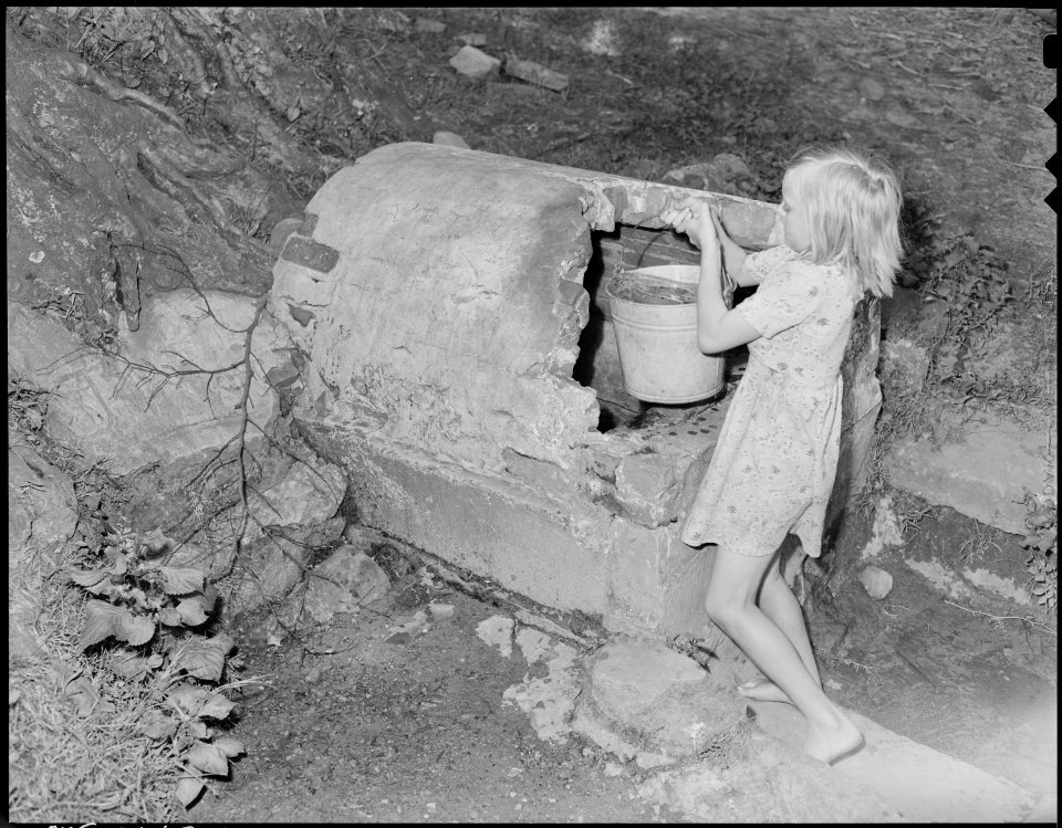Child of a miner getting water from spring. The chief complaint in the camp concerning this water supply was that it... - NARA - 541162