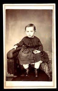 Child sitting in chair holding apple) - James G. Stacy, Foxcroft, Maine LCCN2016653188 photo