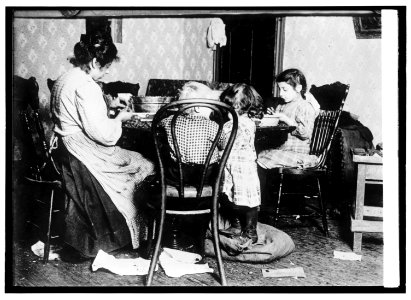 Children 4-6-9, picking nuts in a basement tenement; filth abounds and room is dark & damp. LCCN2016821057