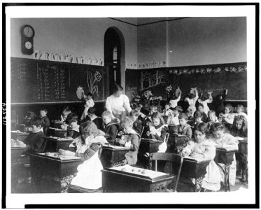 Children modeling clay at desks and drawing on blackboard in Washington, D.C. classroom LCCN95500443