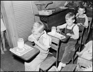 Children of miners eating lunch in schoolroom. Mother of children in 1st two seats brought lunch to school for them.... - NARA - 541236