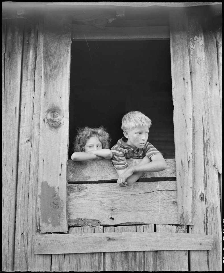 Children of miners look out the kitchen window of the Monroe Jones house. The windows have no panes, the door frames... - NARA - 541187