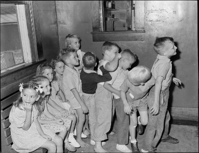 Children waiting to be vaccinated for smallpox and their pre-school examination in outer room of doctor's office.... - NARA - 540701