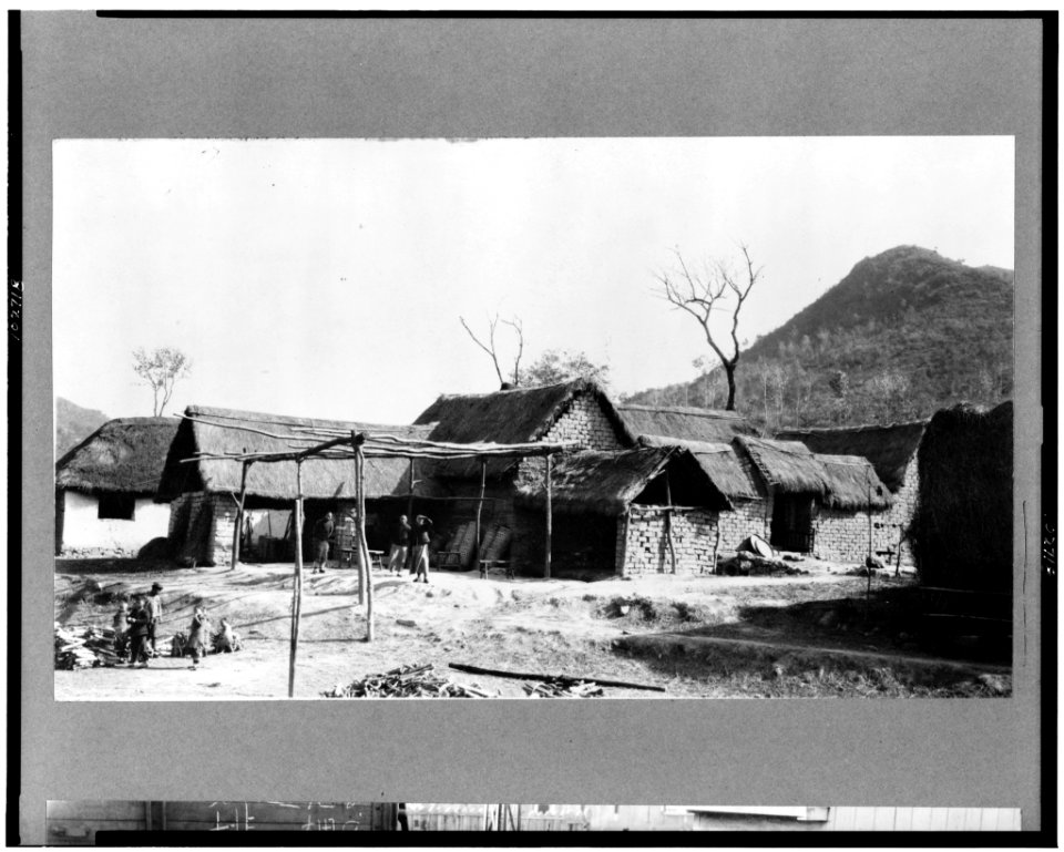 China-mud-brick houses with thatch roofs, people in yard in foreground LCCN91719513