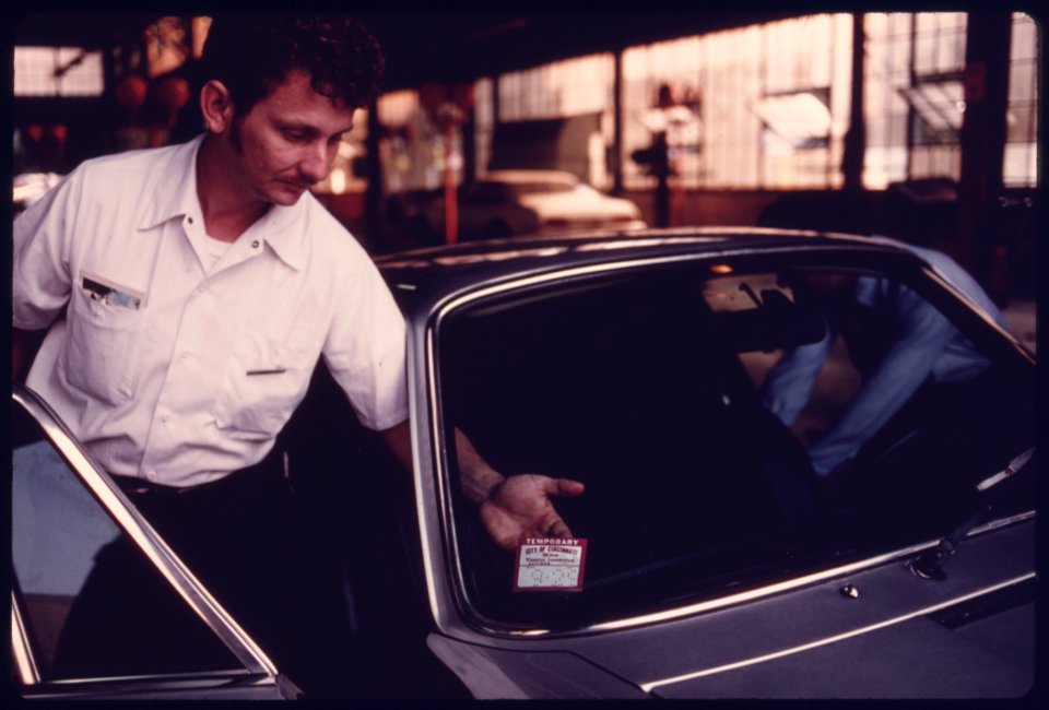 City Employee Affixes a Temporary 30-Day Sticker to the Windshield of a Car after It Had Failed Testing at an Auto Emission Inspection Station in Downtown Cincinnati, Ohio...08-1975 (4266543312)