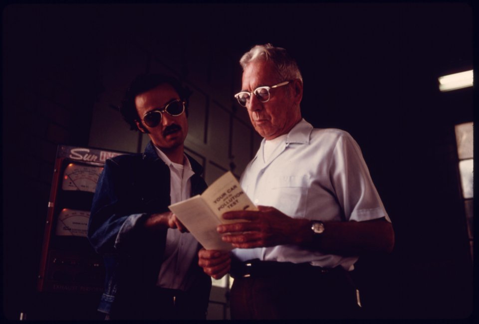 City Employee of an Auto Emission Inspection Station in Downtown Cincinnati, Ohio, Left, Explains a Brochure Given to All Motorists Whose Vehicles Fail the Test 09-1975 (4265790837)