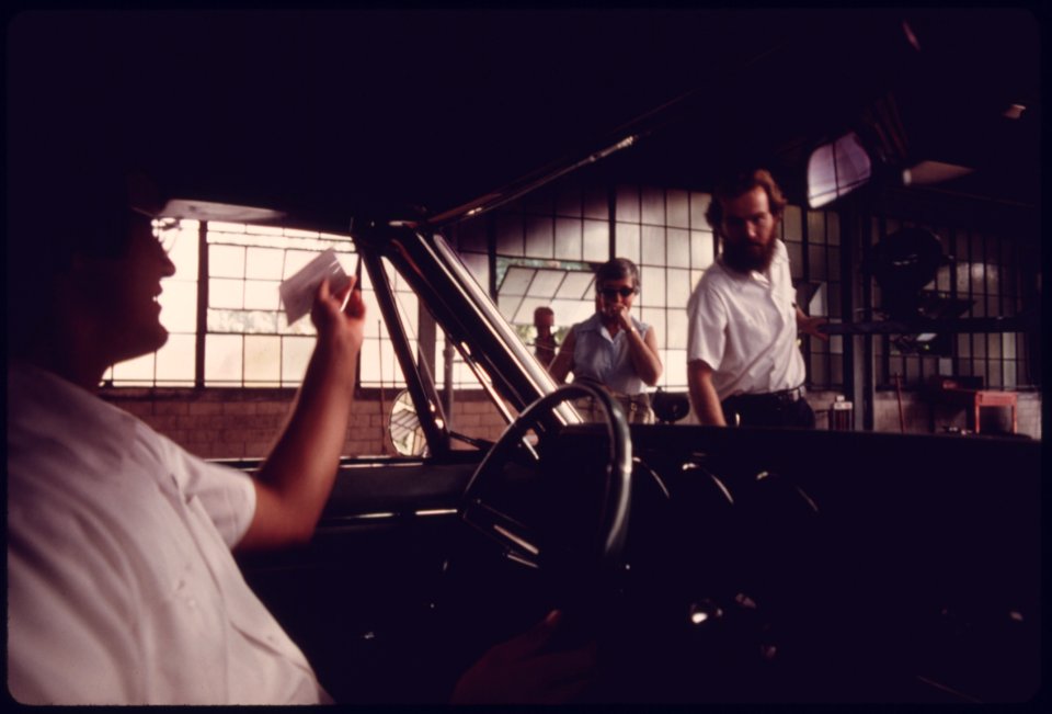 City Employee Inside a Motorist's Car with a Vehicle Information Sheet in His Hand as It Travels through an Auto Emission Inspection Station in Downtown Cincinnati, Ohio...09-1975 (4266537074)