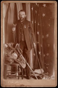 Civil War veteran and amputee Henry A. Seaverns of G.A.R. George W. Perry Post no. 31, Scituate, Massachusetts, in uniform with sword, canteen, and other artifacts, standing on crutches in LCCN2017660647