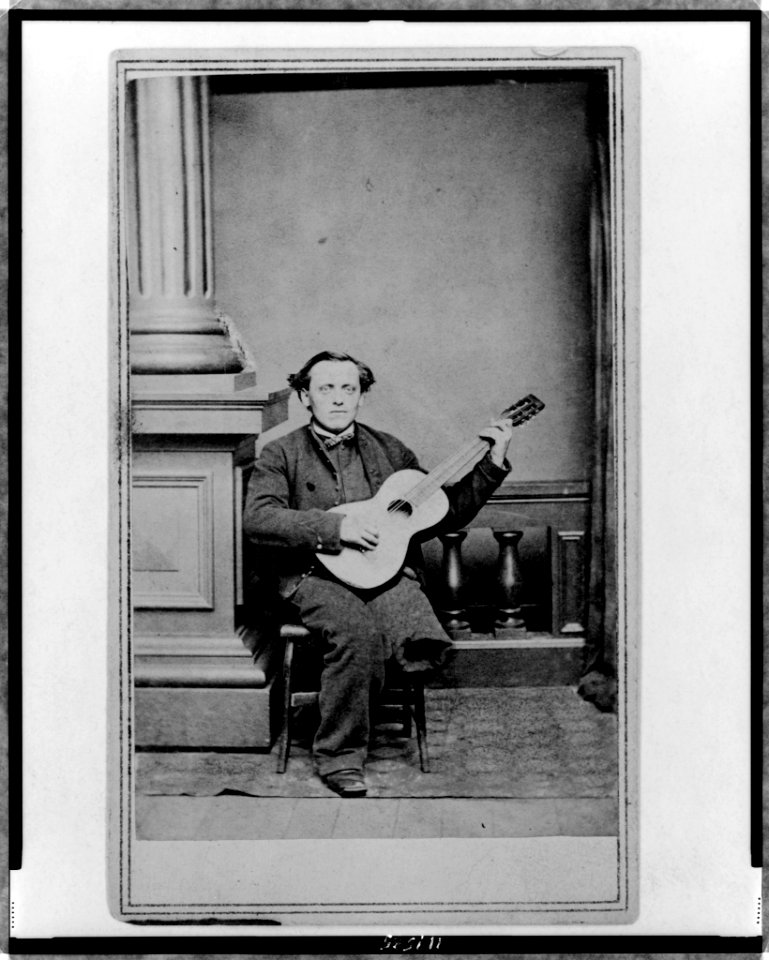 Civil War soldier, with one leg, full-length portrait, seated, facing front, holding guitar LCCN97516655