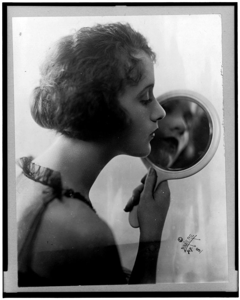 Constance Talmadge, head-and-shoulders portrait, facing right, looking into mirror LCCN96500343