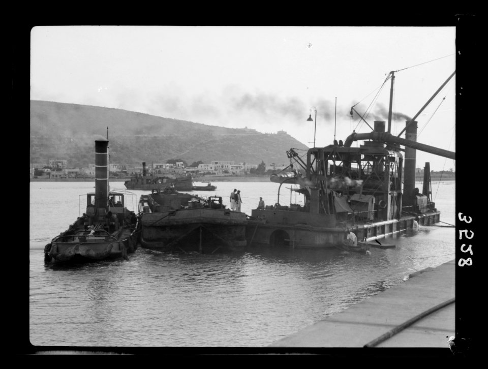 Construction of the Haifa harbour. Haifa harbour. Machinery at work showing Haifa and Carmel point LOC matpc.15389