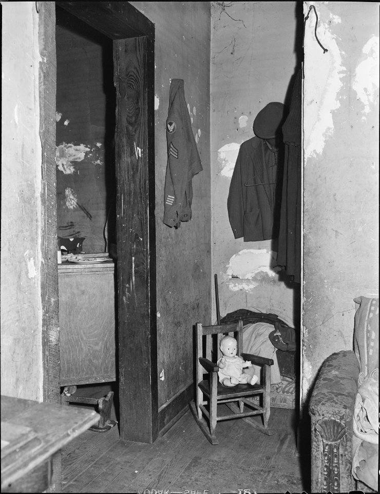 Corner of the living room of Mr. and Mrs. Elige Hicks. The army coat belongs to a married son who has returned to... - NARA - 541028