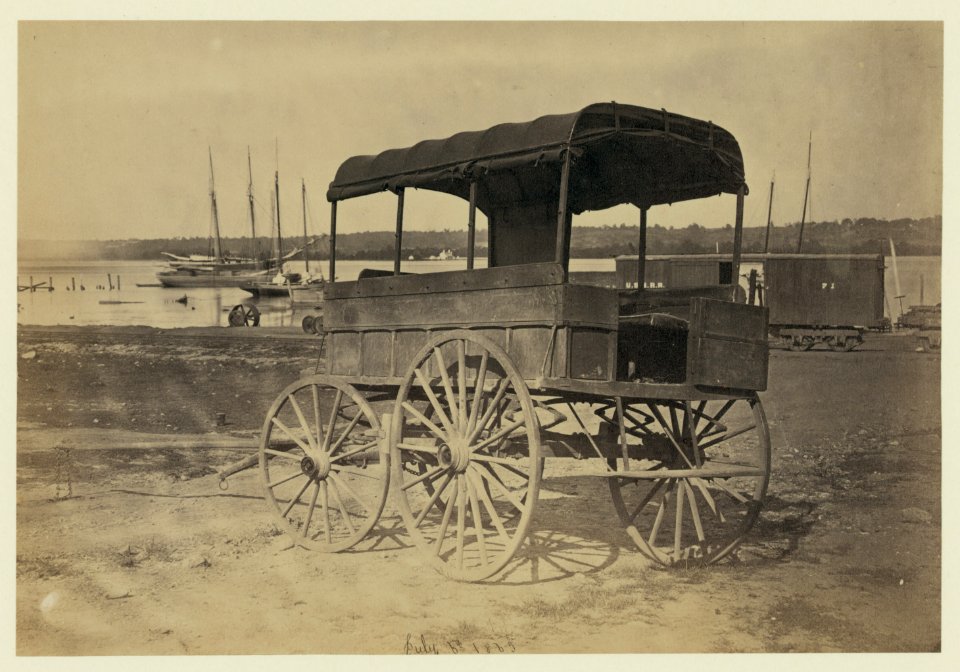 Covered wagon with side curtains rolled up at a military facility LCCN2006681110