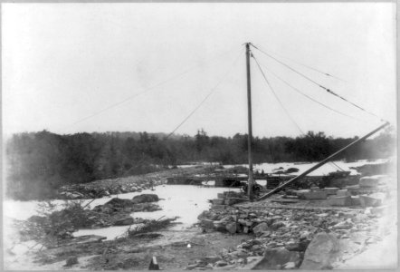 Crane on construction site at edge of river LCCN2002718495