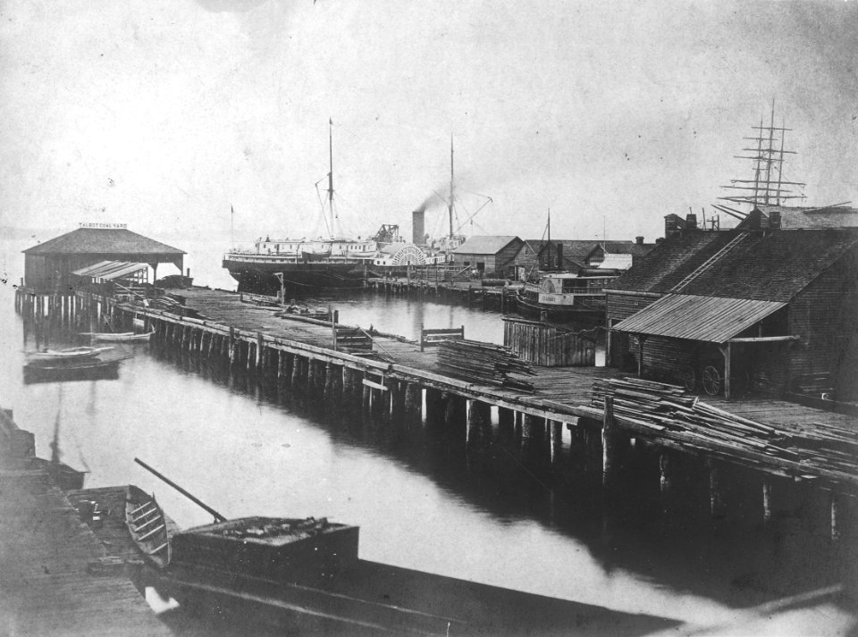 Crawford, Harrington and Yesler's wharves looking west toward moored side wheel steamer DAKOTA, Seattle, ca 1880 (PEISER 142)