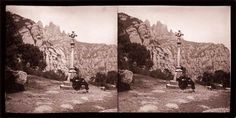 Creu de terme amb gent asseguda a Montserrat