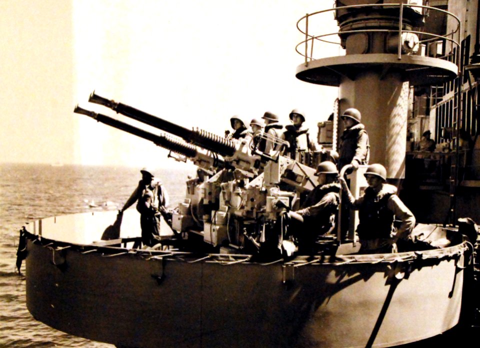 Crew members standing an alert watch on a 40mm anti-aircraft battery onboard USS Rochester (CA 124), flagship of the Seventh Fleet during current operations in the Formosa area