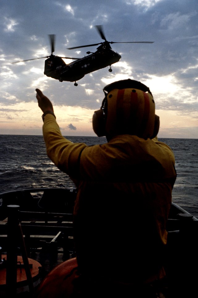 Crewman aboard USS Conserver (ARS-39) signals a UH-46D Sea Knight of HC-11 on 17 September 1983 (6443820)