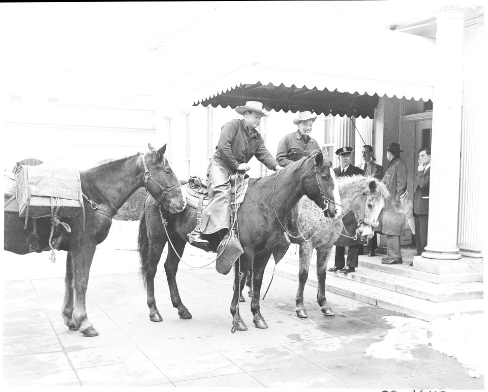 Cross country horseback riders Ned Kennedy and Cecil Cary from Tacoma, Washington wait on their horses by the west... - NARA - 199800