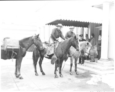 Cross country horseback riders Ned Kennedy and Cecil Cary from Tacoma, Washington wait on their horses by the west... - NARA - 199800