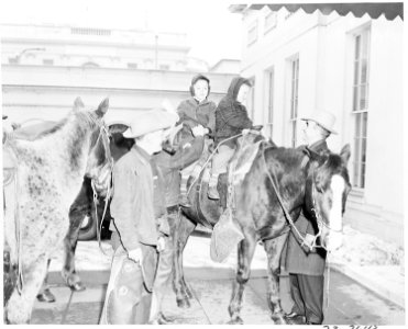Cross country horseback riders Ned Kennedy and Cecil Cary from Tacoma, Washington let two unidentified children sit... - NARA - 199801