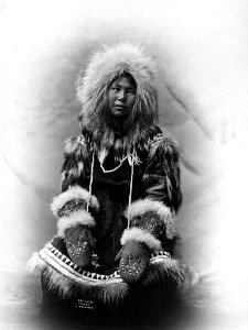 Cross-eyed Inuit woman with chin tattoo wearing fur parka with mittens, Alaska, 1903 (AL+CA 2367)