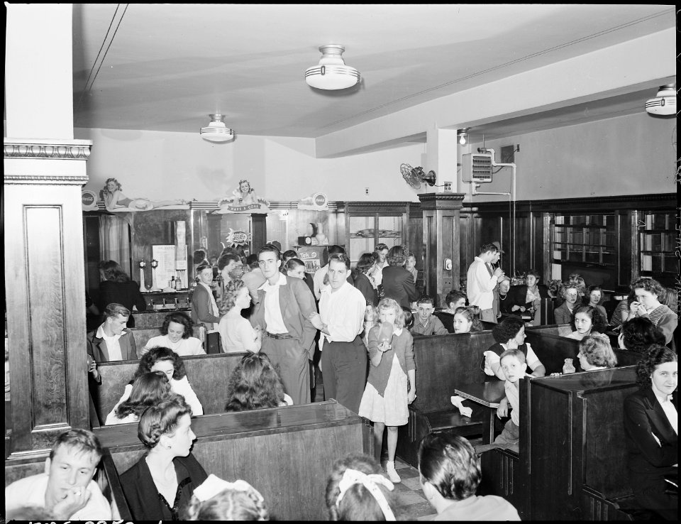Crowd of miners and families in soda fountain prior to movie showing Saturday night. Inland Steel Company... - NARA - 541424