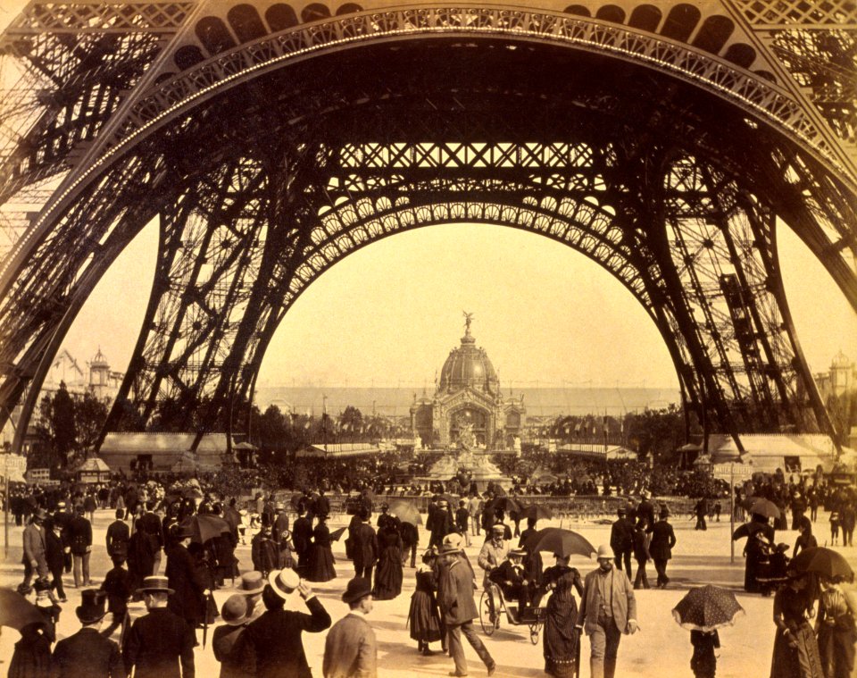 Crowd of people walking under the base of Eiffel Tower, view toward the Central Dome, Paris Exposition, 1889 photo