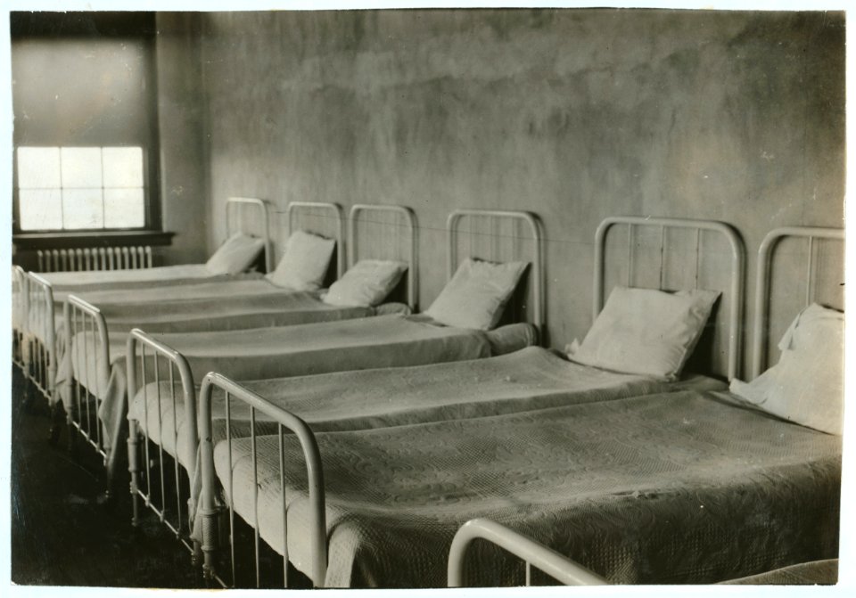 Crowded dormitory (one wall) in Training School for Deaf Mutes. See Gibbons report. LOC nclc.05252