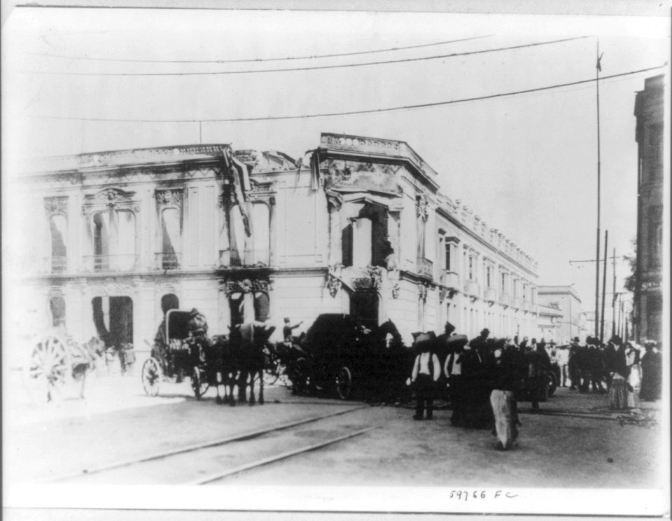 Crowded street outside wrecked building. LCCN2016650899