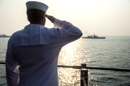 Cryptologic Technician (Operator) Seaman Brian Tunin, assigned to USS Antietam (CG 54), renders honors to a column of Indian naval vessels to mark the conclusion of India’s International Fleet Review 2016