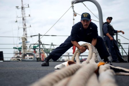 Cryptologic Technician (Collection) 2nd Class Felix Vega fakes down a line as the Arleigh Burke-class guided-missile destroyer USS Howard (DDG 83) gets underway for the at-sea phase of Malabar 2017