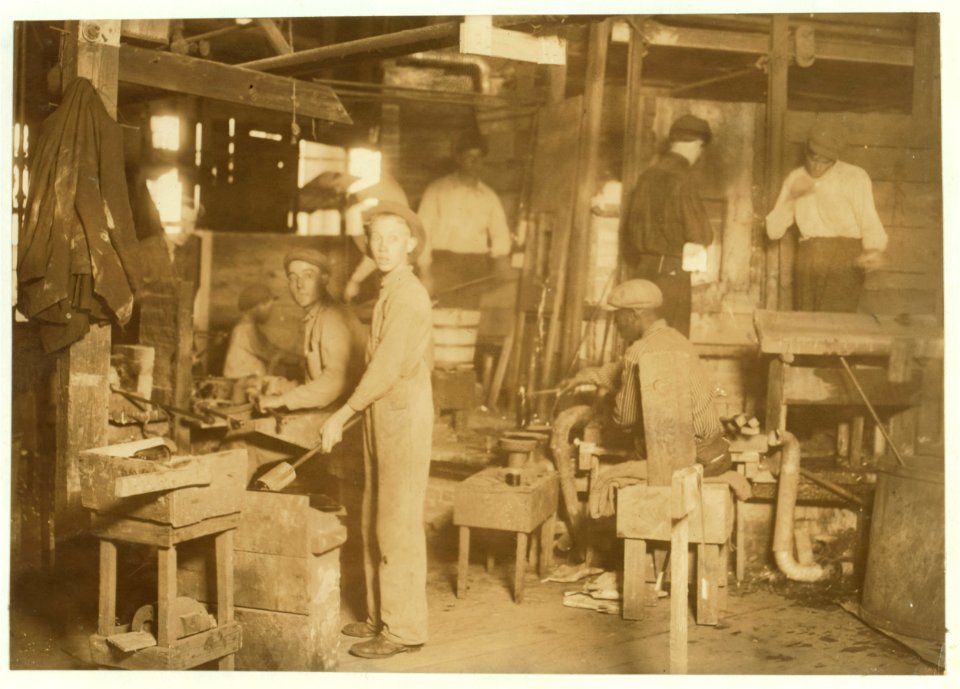 Cumberland Glass Works, Bridgeton, N.J. A young 'holding-mold boy' is seen, dimly, in middle distance to left of centre. Negroes, Greeks and Italians are being employed in many glass houses. LOC nclc.05437