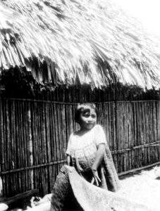 Cuna-indiansk liten flicka vid kanotstäv. Hon har mola (applikationsblus). San Blas. Panama - SMVK - 004457