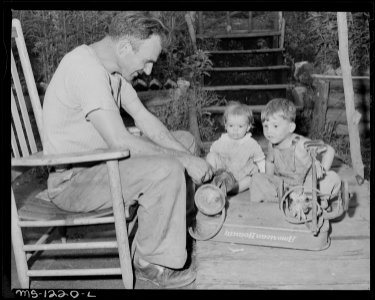 D.B. Henry, miner, who has worked for the company four years, repairs his children's wagon. He has made minor... - NARA - 540739