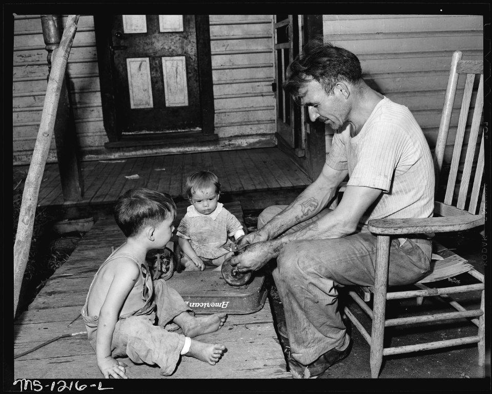 D.B. Henry, miner, who has worked for the company four years, repairs his children's wagon. He has made many minor... - NARA - 540735