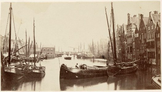 Damrak oostzijde Gezien in noordoostelijke richting. Links Korenbeurs en brug tegenover Oudebrugsteeg, daarachter de stenen Nieuwe Brug photo