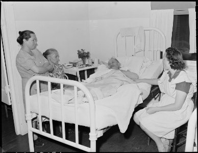 Dan Moore, miner, in company hospital receiving visit from family members. He has double hernia. Black Mountain... - NARA - 541253