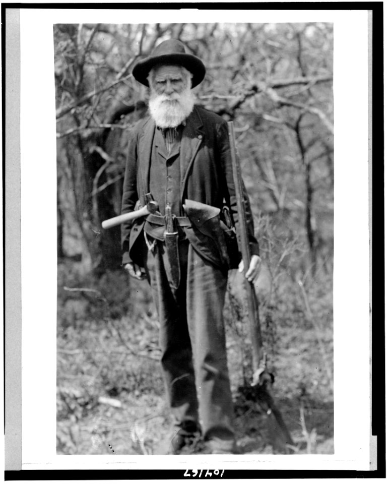 Daniel Freeman standing, holding gun, with hatchet tucked in belt LCCN91783897