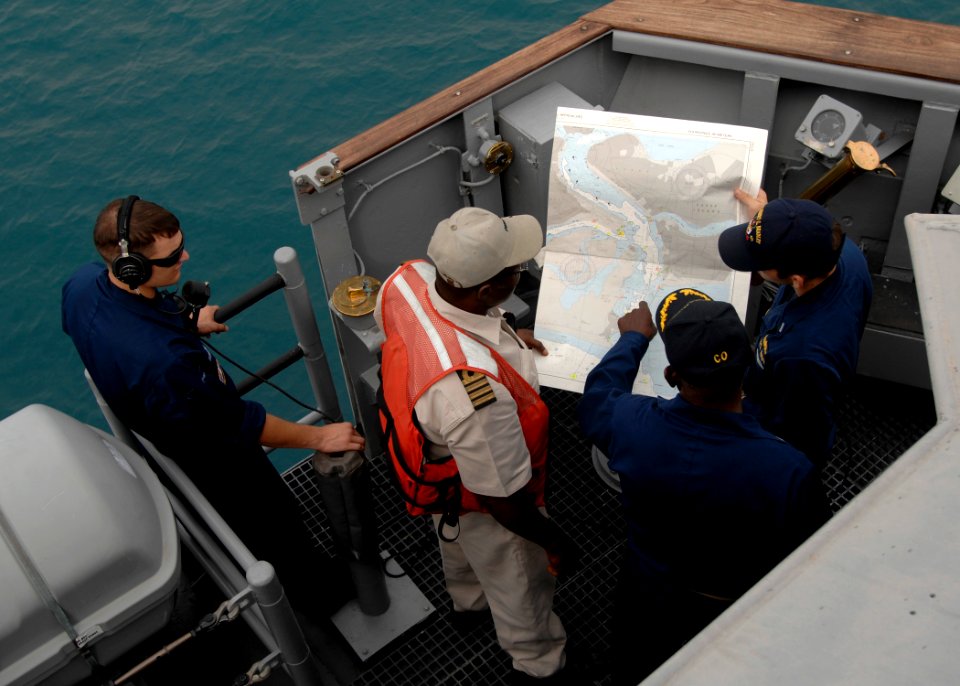 Darryl Brown, commanding officer of USS Robert G. Bradley (FFG 49), talks with a Nigerian pilot while navigating into Lagos