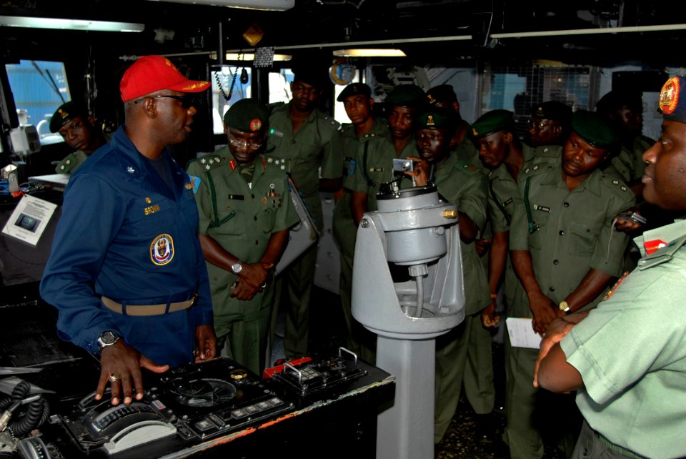 Darryl Brown, commanding officer of USS Robert G. Bradley (FFG 49), speaks about the different watch stations on the bridge during a tour of the ship